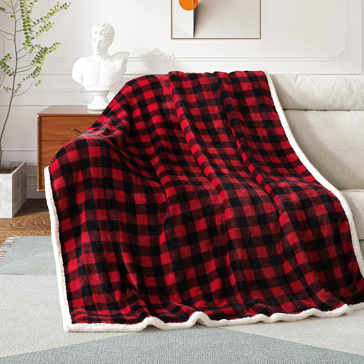 Red and black checkered blanket draped over a sofa in a living room setting.