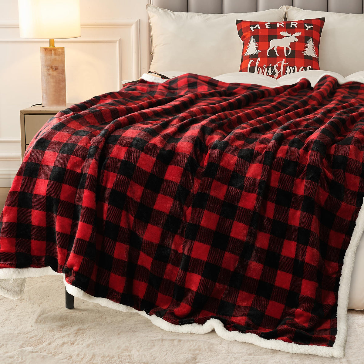 Red and black buffalo plaid sherpa throw blanket spread across a bed with a matching Merry Christmas moose pillow and gold lamp on nightstand