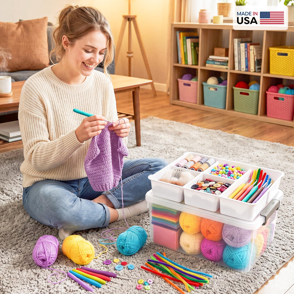 Woman sitting on the floor with craft supplies including yarn and tools, with a container of more supplies next to her.