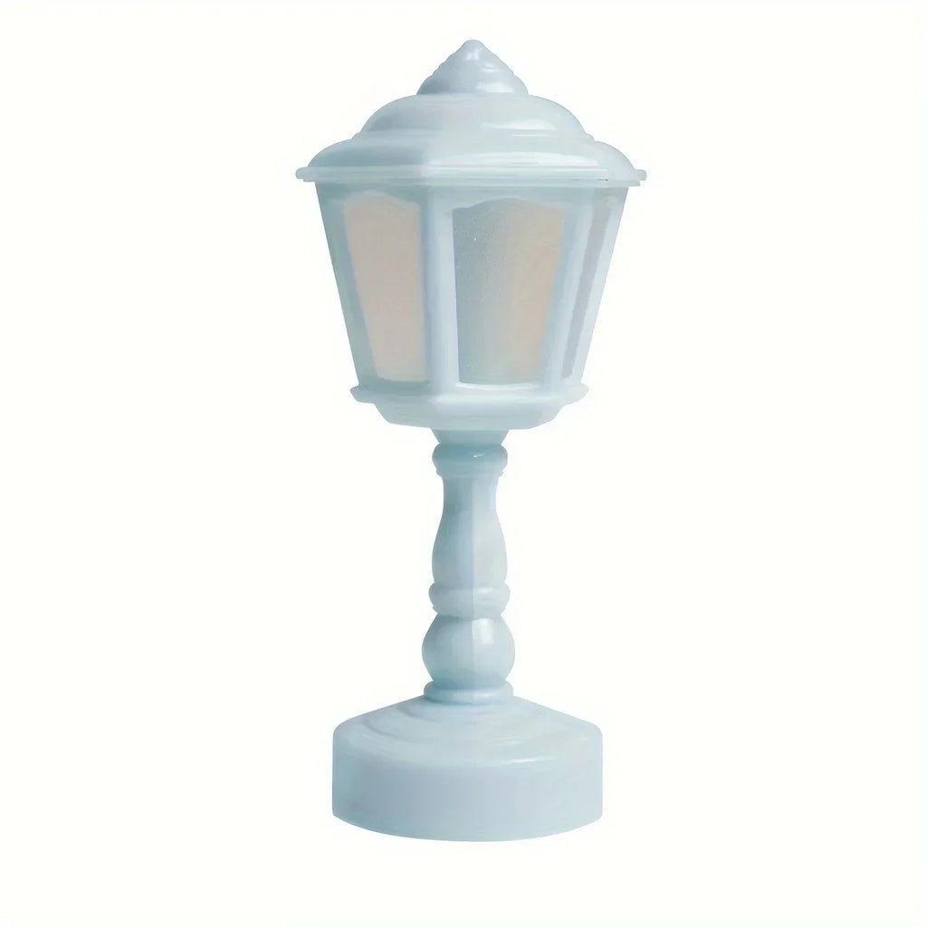 A miniature decorative lamp with a pale blue body and frosted glass panels, set against a plain white background.