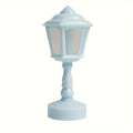 A miniature decorative lamp with a pale blue body and frosted glass panels, set against a plain white background.