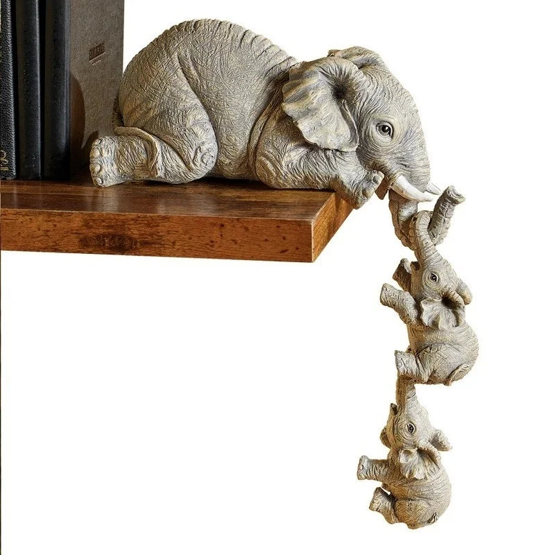 Close-up of elephant shelf sitter figurine set on wooden shelf showing detailed resin texture of mama and two baby elephants