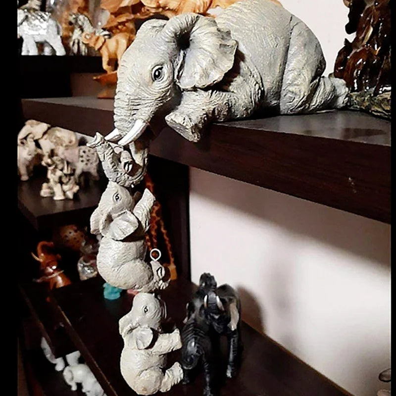 Resin elephant family shelf sitter displayed on dark wood bookcase surrounded by other figurines