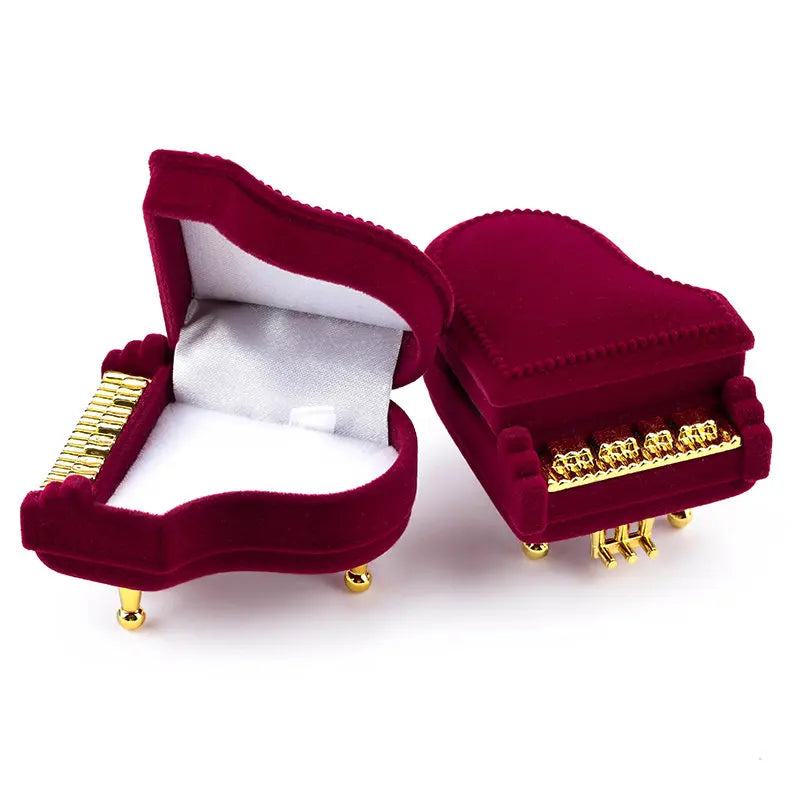 Red velvet jewelry box with gold accents on a white background