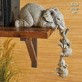 two baby elephants hanging below by their trunks