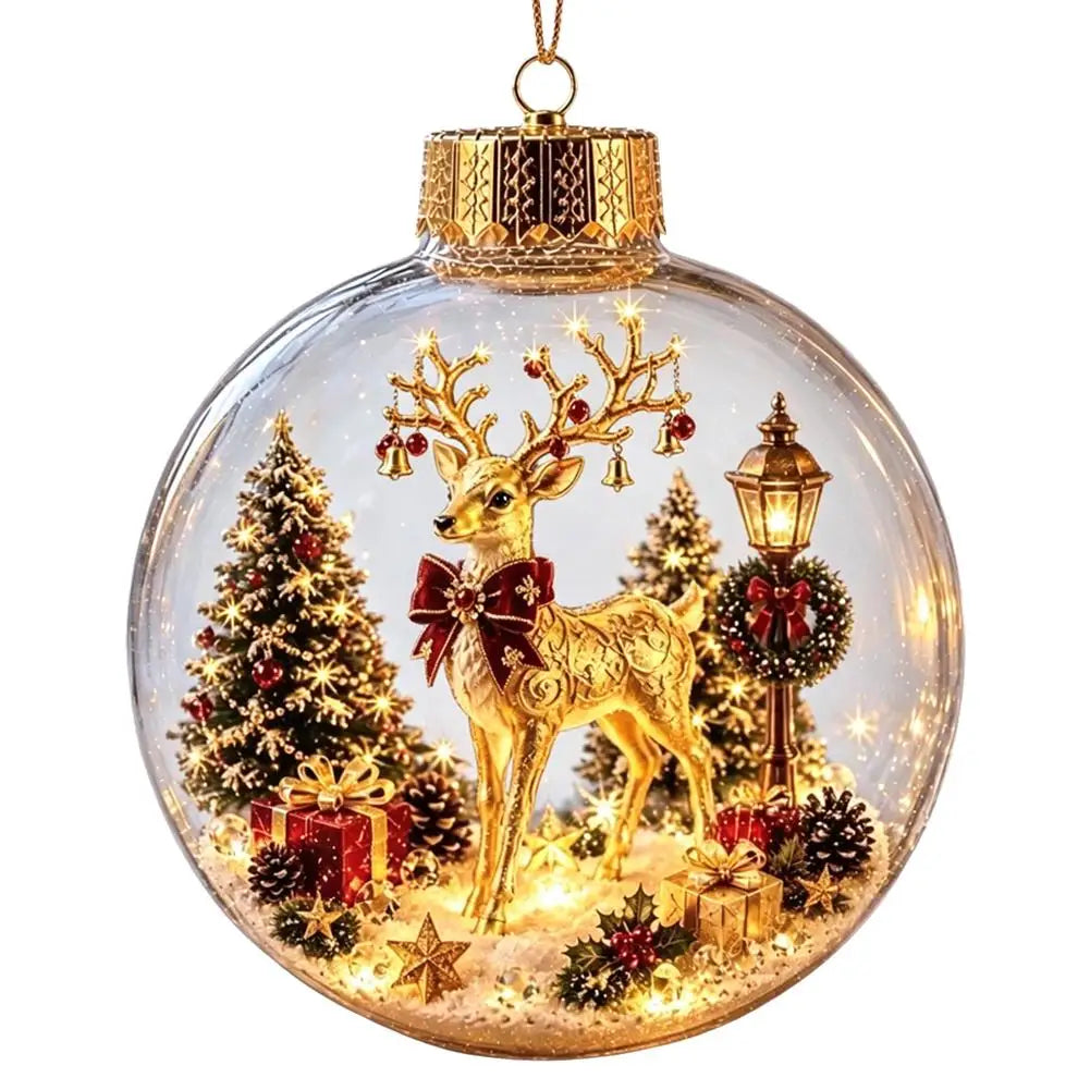 A clear glass Christmas ornament ball with a gold cap and hanging loop, featuring a golden deer with antlers, lit holiday trees, ornaments, a lamp post, and warm white lights inside.