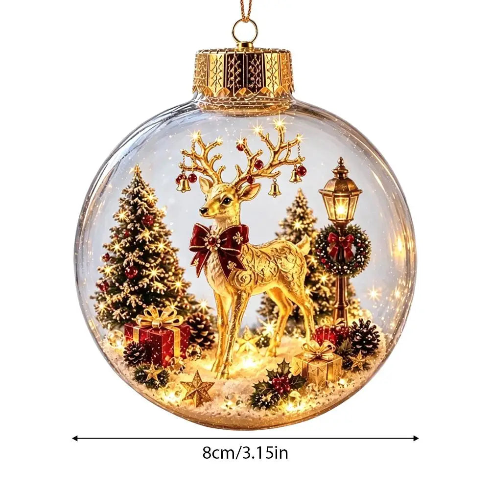 A clear round Christmas ornament with a gold cap and hanger, featuring a golden deer, lit Christmas trees, gifts, pinecones, and a street lamp inside. A dimension label at the bottom reads 8cm/3.