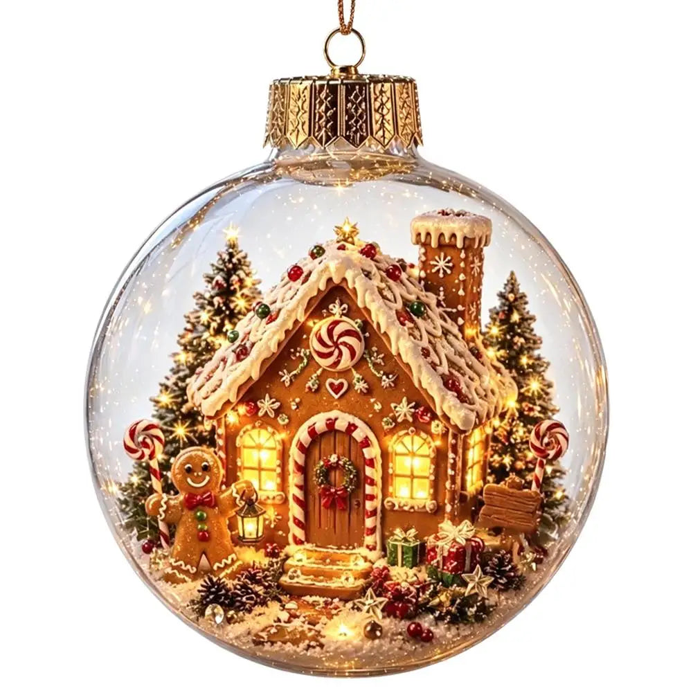 A clear glass Christmas ornament ball featuring a detailed gingerbread house scene with warm white string lights, decorated candy canes, small trees, a gingerbread man, and festive details, shown on a plain white background.