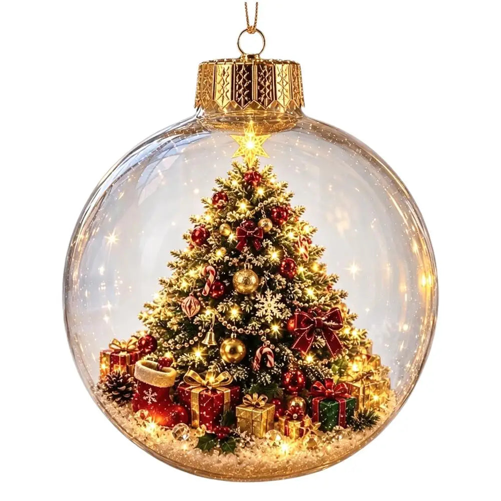 A clear glass Christmas ornament ball with a gold cap and hanging loop, containing a miniature lit Christmas tree, red ornaments, snow-like dusting, and wrapped gifts inside, shown on a white background.