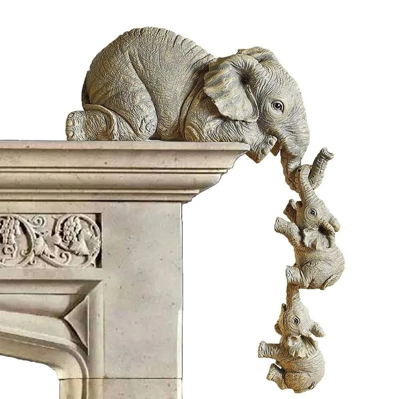 Elephant family resin figurine set displayed on a white marble mantelpiece with mama elephant on top and two babies hanging below
