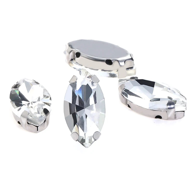 Crystal clear glass navette rhinestones with silver settings in 3 sizes on white background